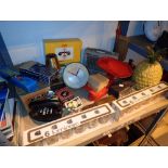 Shelf of retro items mainly unused radio clocks iron timers etc