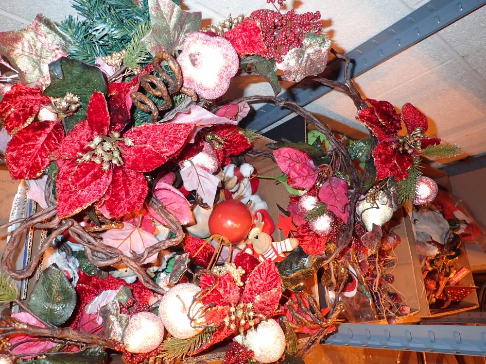 Two shelves of Christmas decorations including wall hanging decorations