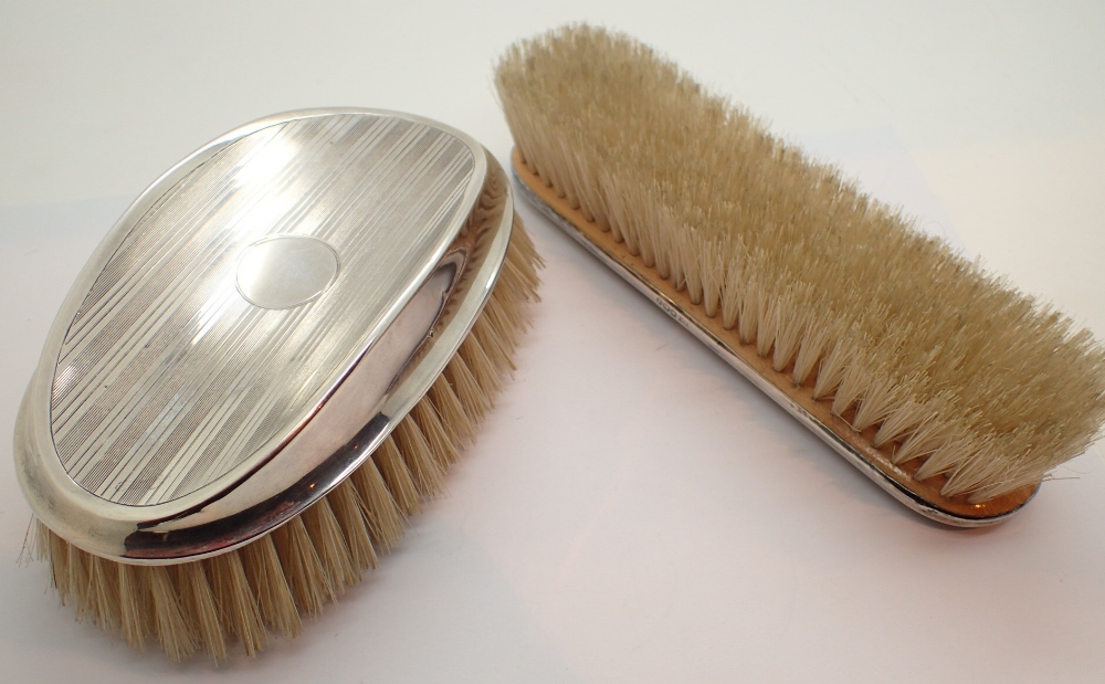 Two silver hairbrushes one with hallmark