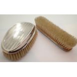Two silver hairbrushes one with hallmark