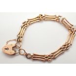 9ct yellow gold three bar gate bracelet with padlock clasp L: 12 cm 9.