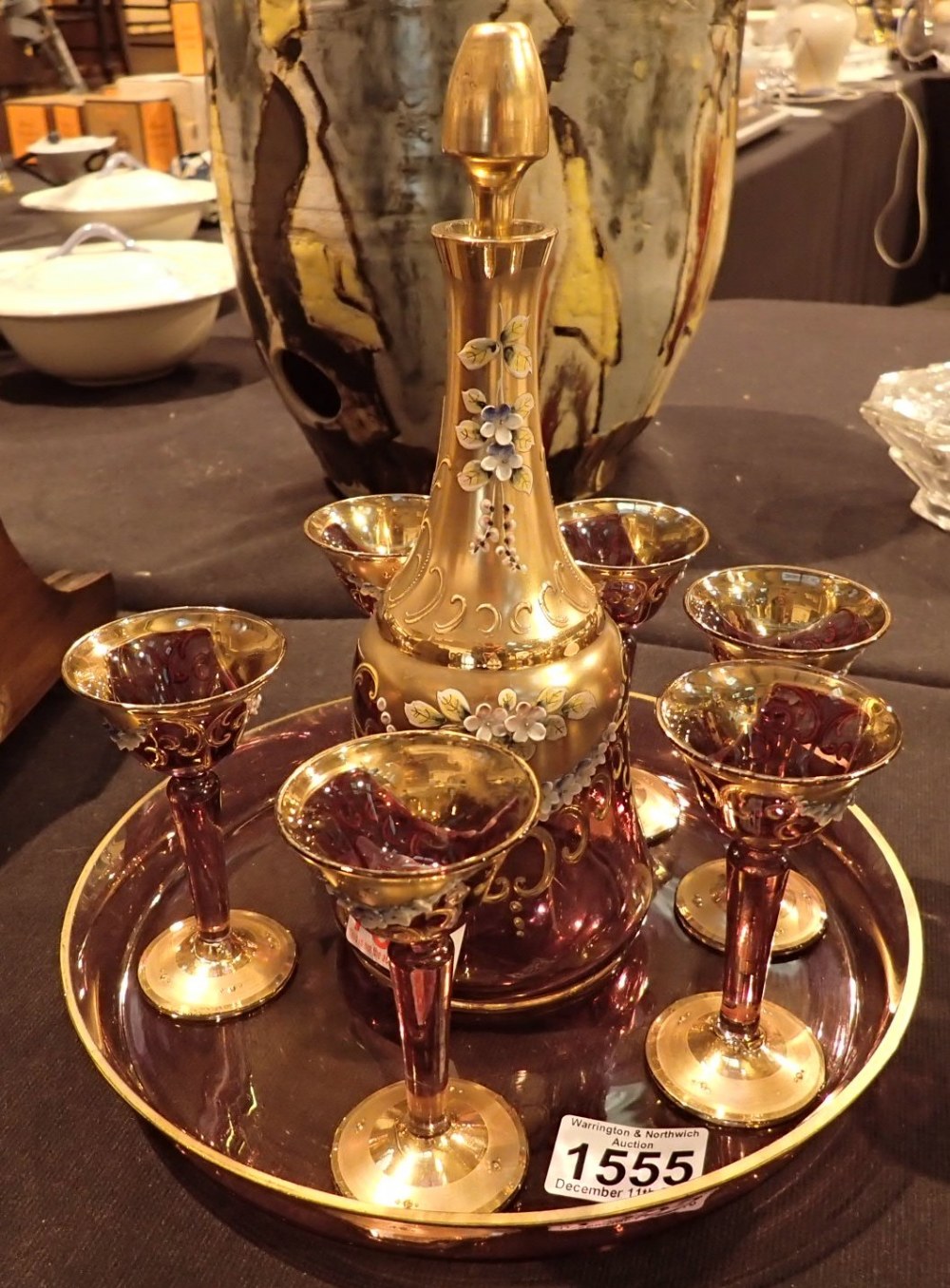 Gilt decorated cranberry glass decanter with matching glasses