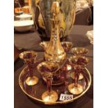 Gilt decorated cranberry glass decanter with matching glasses