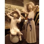 Two Lladro figurines boy and girl with hats tallest H: 25 cm