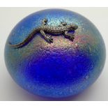 Iridescent glass paperweight in the style of John Ditchfield surmounted by a metal lizard