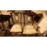 Four Edwardian carved oak upholstered dining chairs including two carvers