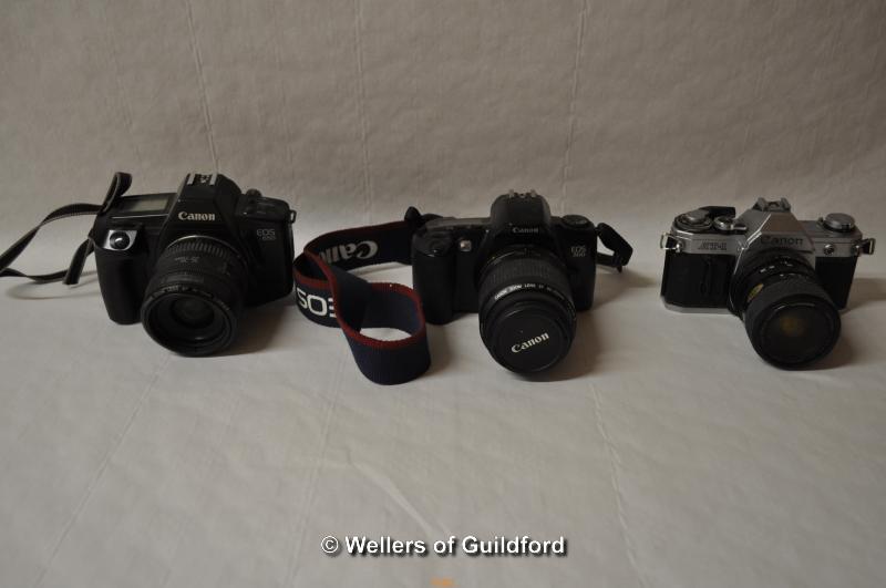 Four Canon cameras with lenses. Camera bodies include: EOS 650 (1105477); EOS 500 (1309150); AT-1 (