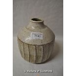 A stoneware fluted vase in the style of David Leach, with white speckled glaze and fluted sides,