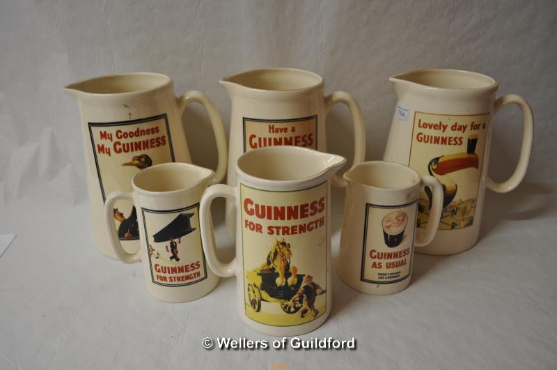 Six Guiness jugs by Diamond Print & Ceramics, three large, 23cm, one medium, 18.5cm, and two