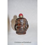 A Chinese horn snuff bottle carved as a drogon, red cabochon stone to lid, 8.5cm tall.