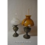 Two oil lamps, one with amber coloured glass shade, the other with milk glass.