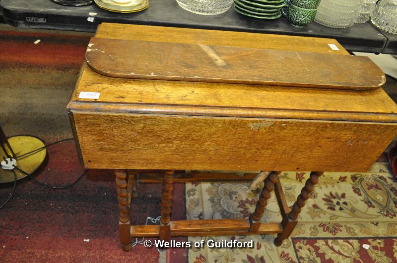 A rectangular oak dropleaf occasional table on barleytwist supports.