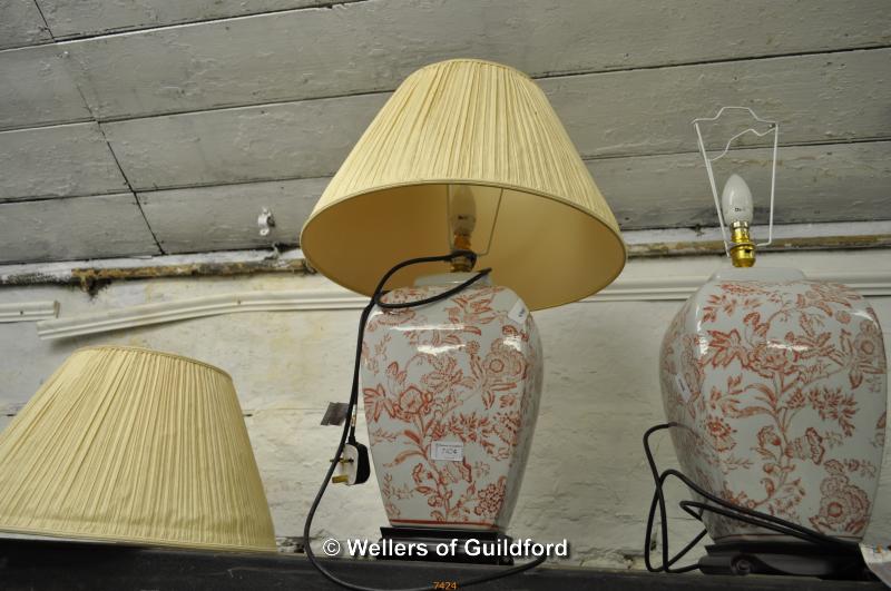 A pair of table lamps of bulbous square form with terracotta pattern on pale ground, with pleated