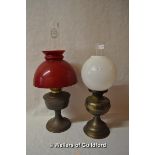 Two brass or copper oil lamps, one with milk glass shade, the other red glass.