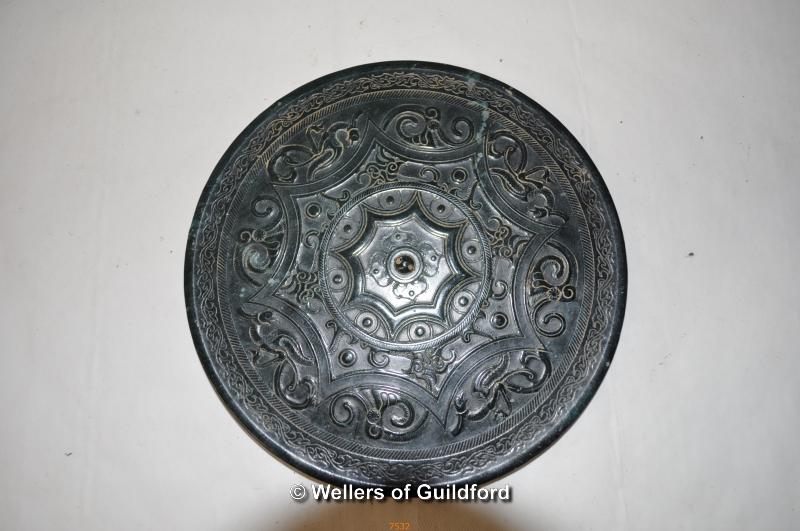 A Chinese dark green jade circular disc, carved decoration on one side, 15cm diameter.