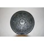 A Chinese dark green jade circular disc, carved decoration on one side, 15cm diameter.