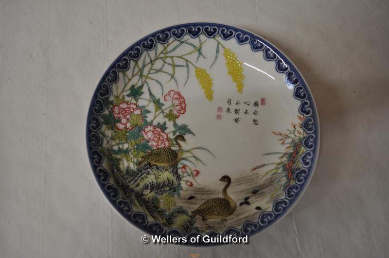 A Chinese polychrome plate decorated with a scene of geese amidst flowers and flowers, inscribed and