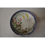 A Chinese polychrome plate decorated with a scene of geese amidst flowers and flowers, inscribed and