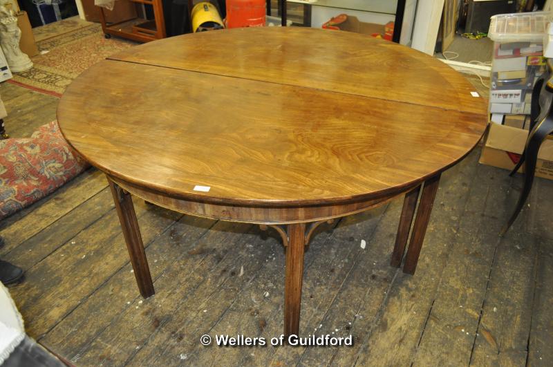 A large 19th Century circular mahogany dining table with gateleg action, later crossbanding and with