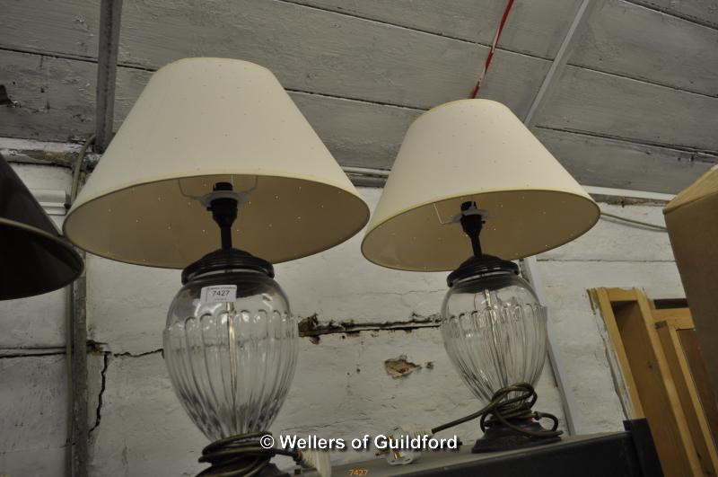 A pair of glass ovoid table lamps with cream shades, 51cm overall.