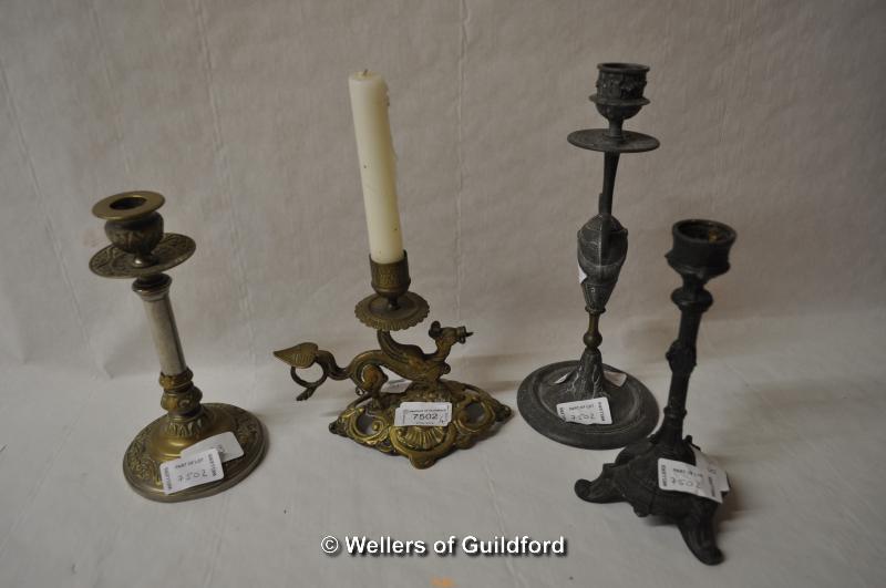 A brass chamberstick cast as a dragon; three further candlesticks (4).