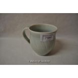 A small pottery mug in pale green glaze, with stylised wrythen pattern, impressed star mark at