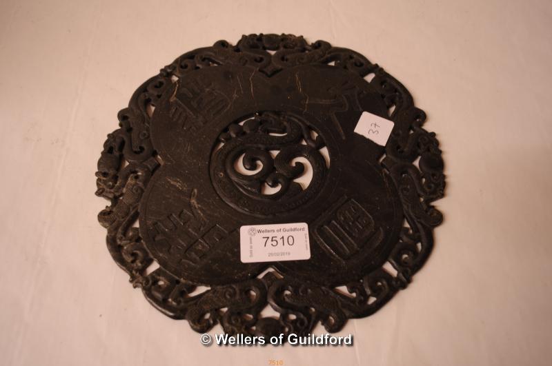 A Chinese green hardstone disc carved with dragons, 21cm diameter.