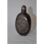 A Chinese horn snuff bottle carved with dragons, red cabochon stone lid.