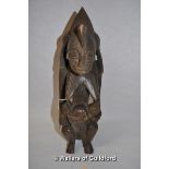 An African carved wooden fertility figure of a woman breast feeding her baby, 32cm.