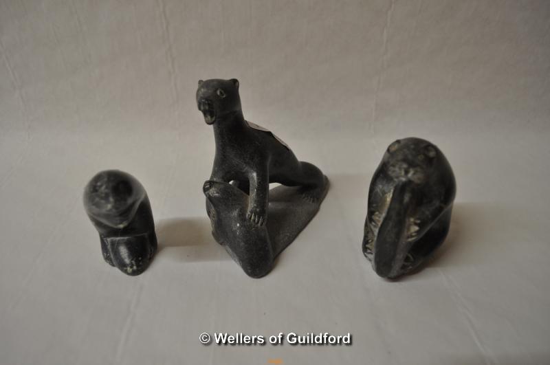 Three Inuit eskimo carvings; one of a bear catching a seal, 10.5cm, an otter eating a fish, 9cm,