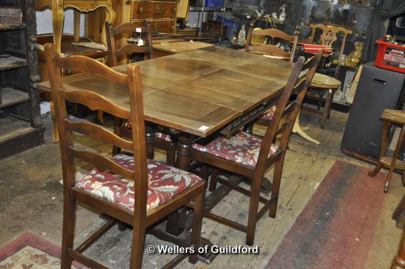 An oak drawleaf table and four ladderback chairs.