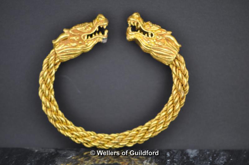 A gold coloured Bracelet with dragon heads