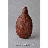 A Chinese snuff bottle moulded with a fish, red cabochon stopper.