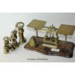 A set of brass and mahogany postal scales with five stacking weight; a set of seven brass bell
