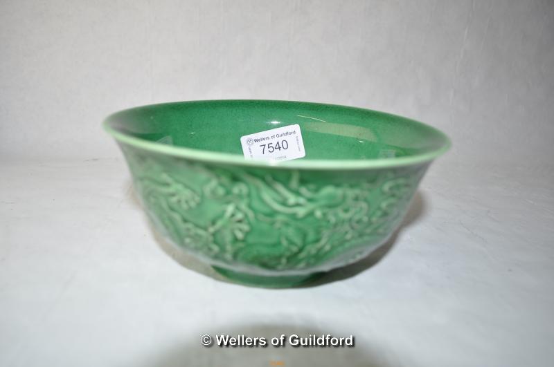 A Chinese green ground bowl, relief decorated with dragons, impressed mark, 15.5cm diameter.