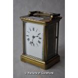 A brass carriage clock , the white enamel dial with Roman numerals, 10.75cm excluding handle.