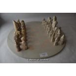 Sandstone chess set including board, pieces carved as African figures and animals