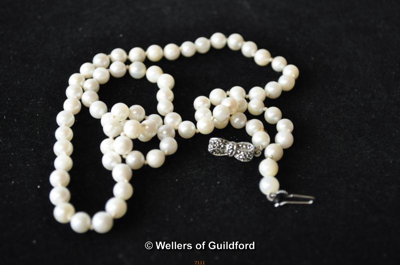 A single strand of cultured pearls with silver clasp, 22 inches.