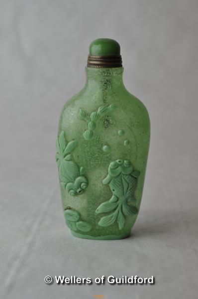 A Chinese green glass snuff bottle moulded with heron, birds and lotus flower.