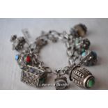 An Indian white metalcharm bracelet with eight charms.