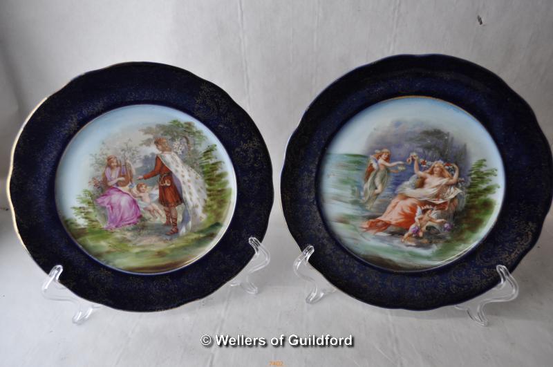 A pair of Vienna small plates with central paiting depicting figures in an outdoor setting, 18cm.