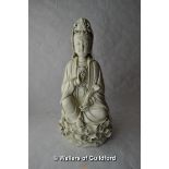 A blanc-de-chine figure of Guanyin holding a sceptre, seated on a lotus flower, 26cm.