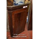 GEORGE III MAHOGANY HANGING CORNER CABINET WITH PANELLED DOOR ENCLOSING SHAPED SHELVES, 104CM (