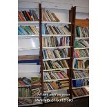 SHELVING UNIT CONTAINING A LARGE SELECTION OF MIXED PAPERBACK BOOKS