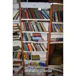 SHELVING UNIT CONTAINING A LARGE SELECTION OF MIXED PAPERBACK BOOKS