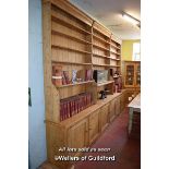 VERY LARGE PINE OPEN BOOKCASE WITH THREE BANKS OF SHELVES OVER THREE PAIRS OF PANELLED CUPBOARD