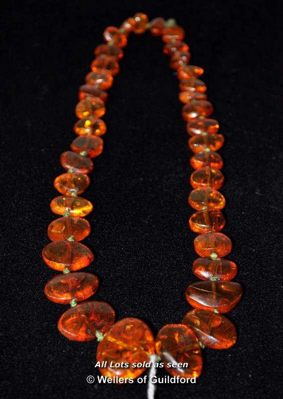 An amber necklace of flat beads, 25g, approx 43cm