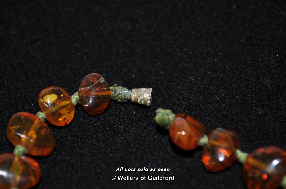 An amber necklace of flat beads, 25g, approx 43cm - Image 5 of 6