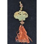 A Chinese hardstone pendant carved as a lotus flower with pink tassles.