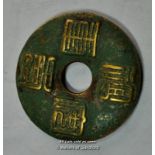 A Chinese brass disc/coin with verdigris finish.